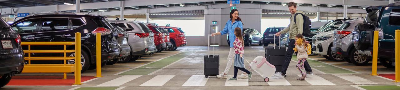 family walking in the Auckland Airport Transport Hub car park on the way to a fun holiday