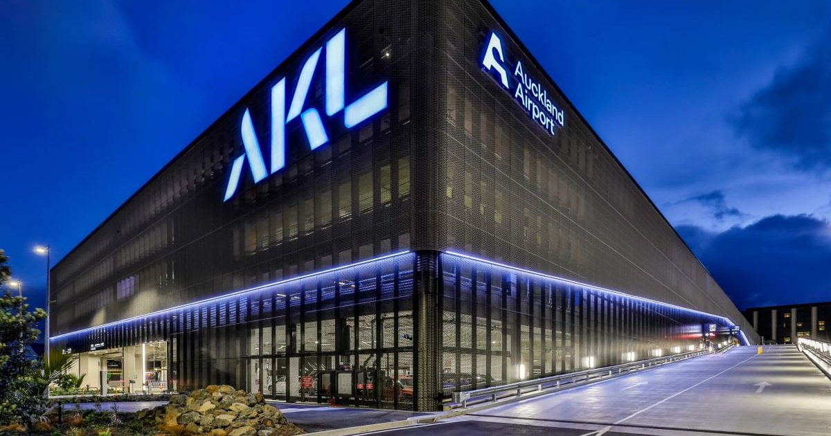 Auckland Airport Transport Hub car park and rental cars pick up point shown at night with a large AKL light feature adorning the side of the structure